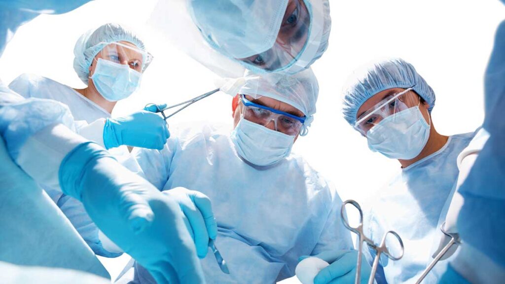 Cirurgias: foto de médicos vistos de cima, sob a perspectiva de um paciente na mesa de uma cirurgia