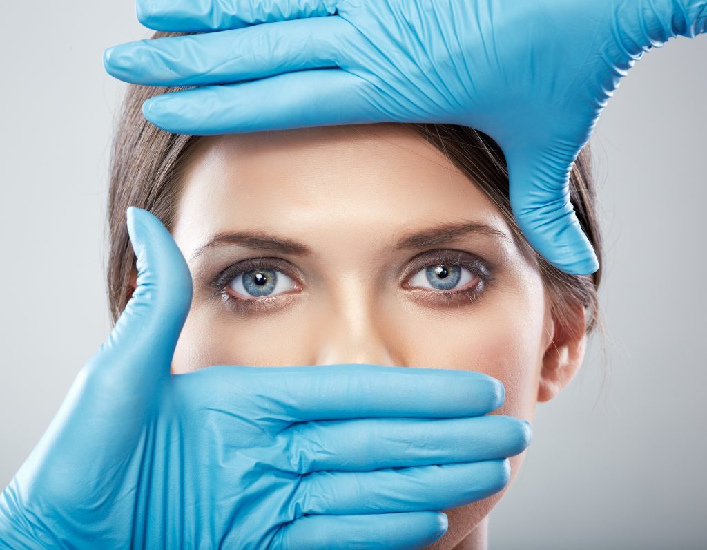 Procedimentos estéticos: Foto dos olhos de uma mulher sendo destacada por luvas cirúrgicas