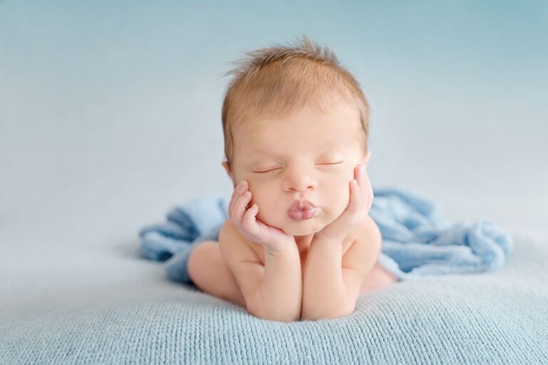 Plano de saúde Unimed para recém-nascidos: Foto de bebê deitado e apoiando as mão no queixo